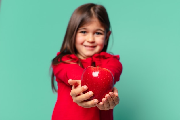 Pretty little girl happy expression and holding an apple