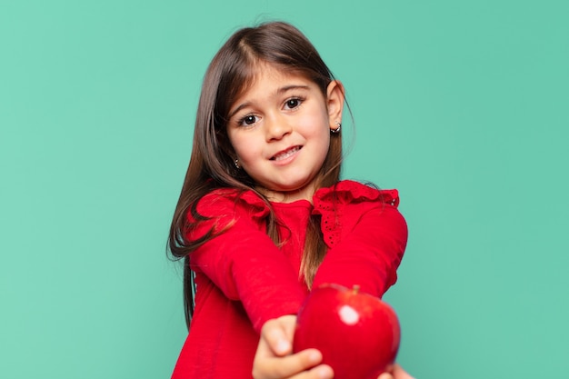 Pretty little girl happy expression and holding an apple