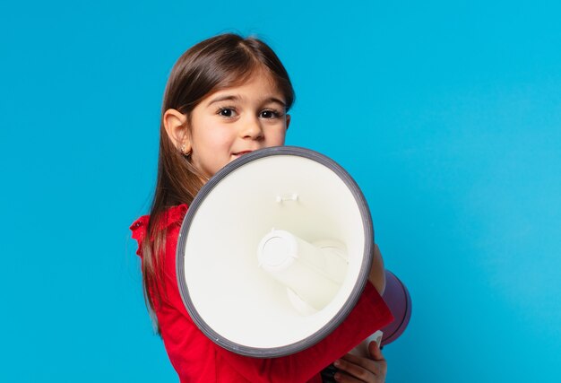 Espressione felice della bambina graziosa e che tiene un megafono