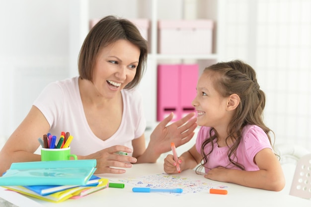 Pretty little girl and her mother doing homework