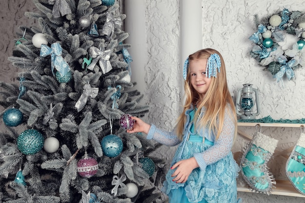 Pretty little girl near the new year tree