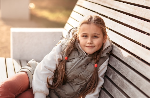 Pretty little girl resting in autumnal park