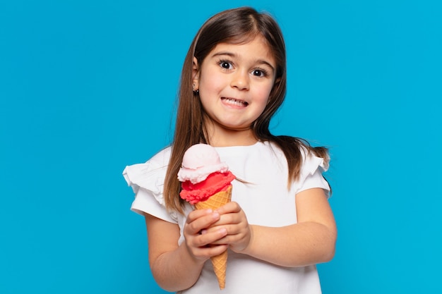 симпатичная маленькая девочка испуганно выражение и держит мороженое