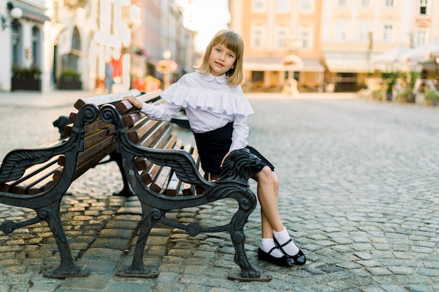 Pretty little girl in white shirt and black skirt