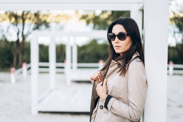 Pretty long hair brunette girl in sunglasses relaxing outdoor.