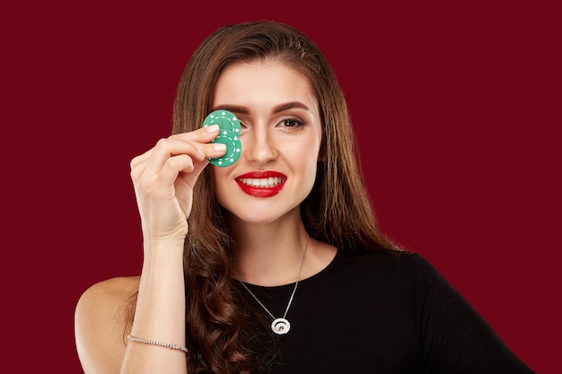 Pretty long hair woman in black dress holding chips for gambling