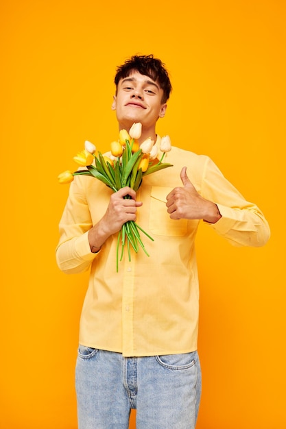 Pretty man give flowers wear spectacles yellow shirt isolated background unaltered. high quality photo