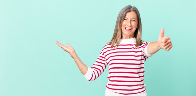 Pretty middle age woman feeling proud,smiling positively with thumbs up