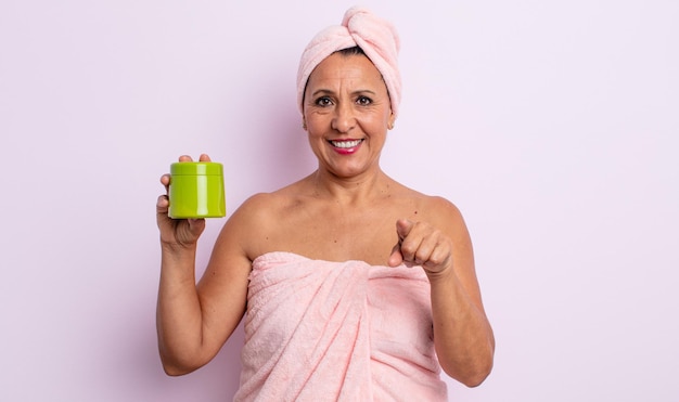 Pretty middle age woman pointing at camera choosing you. shower and hair product concept