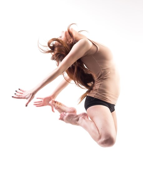 Pretty modern slim hiphop style teenage girl jumping dancing isolated on a white studio background