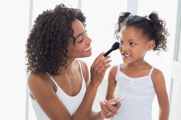 Pretty mother teaching her daughter about makeup 