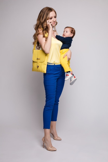 Pretty mother walking with little kid and taking selfie