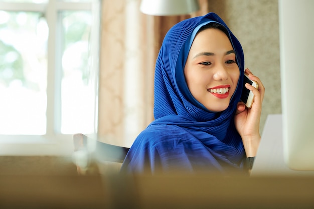 Pretty muslim woman calling on phone