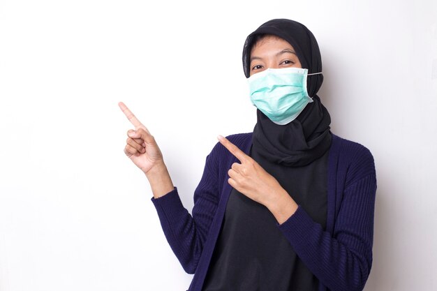 Pretty muslim young asian woman  with medical protective face mask to protect infection from coronavirus on isolated white space