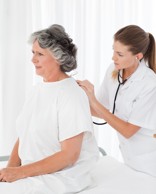 Pretty nurse taking the heartbeat of her patient