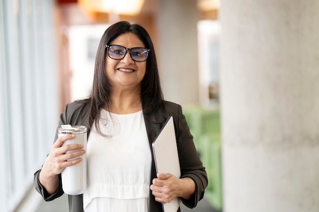 Pretty older Asian business woman successful confident smiling at camera in a financial building