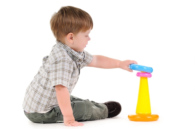 Pretty one year little baby playing with colorful pyramid