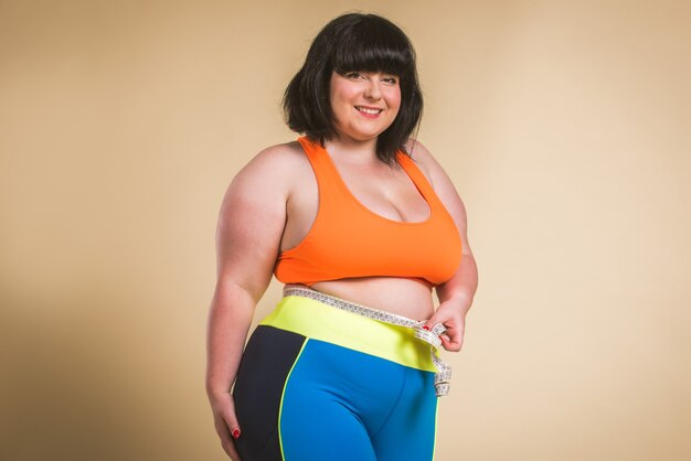 Pretty oversize woman wearing sportswear posing in studio