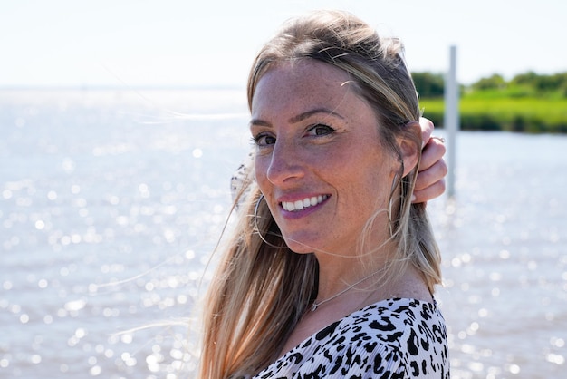 Pretty portrait beautiful blonde woman on beach girl smiling outdoors