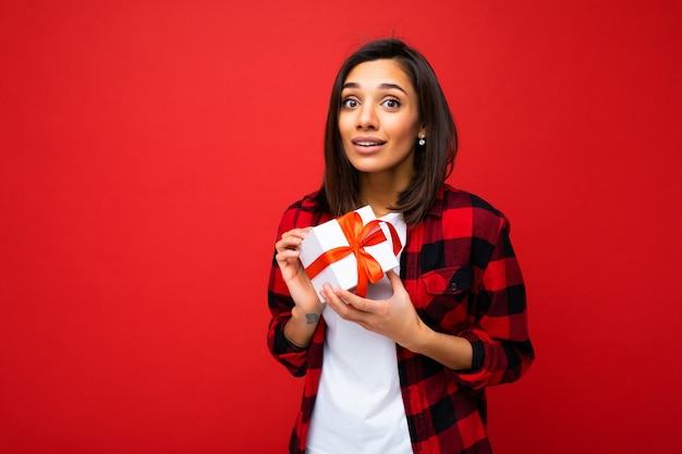 Pretty positive young brunette woman isolated wall wearing white