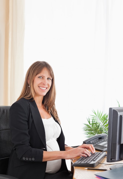 Pretty pregnant female working with a computer