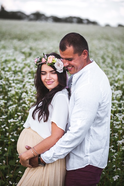 Foto bella donna incinta con suo marito nel campo