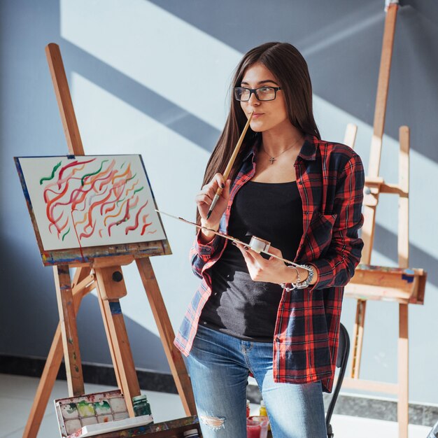 Pretty Pretty Girl artist paints on canvas painting on the easel.