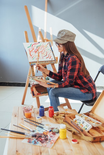 Pretty Pretty Girl artist paints on canvas painting on the easel.