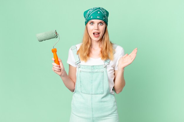 Una bella donna dai capelli rossi che si sente felice e stupita per qualcosa di incredibile che dipinge il concetto di casa