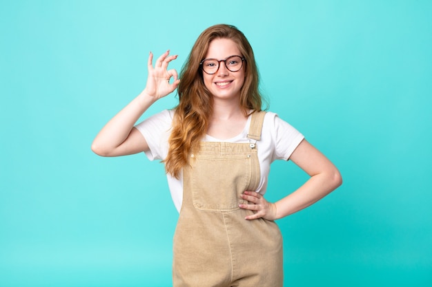 Photo pretty red head woman feeling happy, showing approval with okay gesture