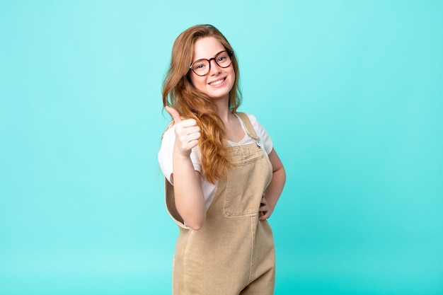 Pretty red head woman feeling proud,smiling positively with thumbs up