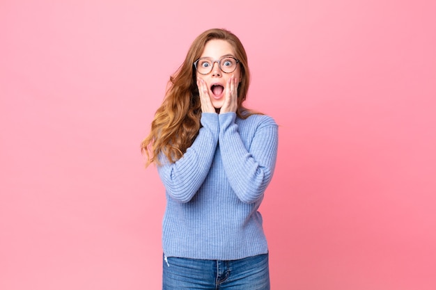 Pretty red head woman feeling shocked and scared