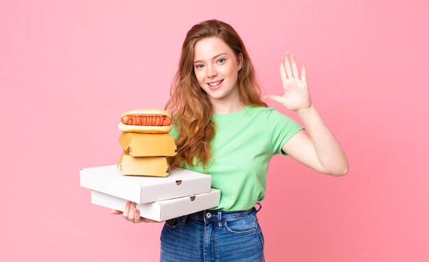 pretty red head woman holding take away fast food boxes