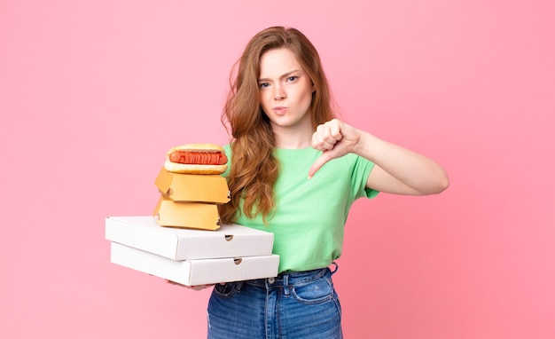 Pretty red head woman holding take away fast food boxes