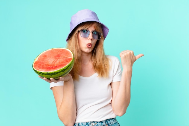 かなり赤い頭の女性とスイカを持っています。夏のコンセプト