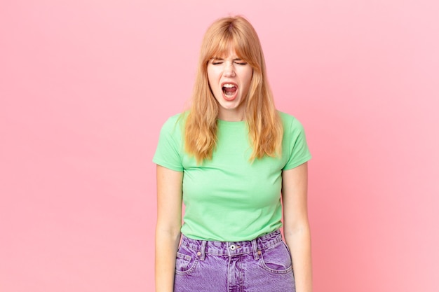 Pretty red head woman shouting aggressively, looking very angry