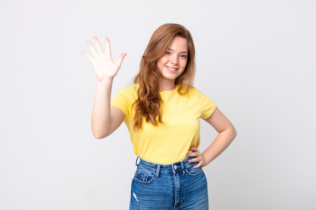 Pretty red head woman smiling and looking friendly, showing number five