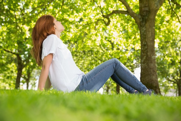 Pretty redhead relaxing in the park 