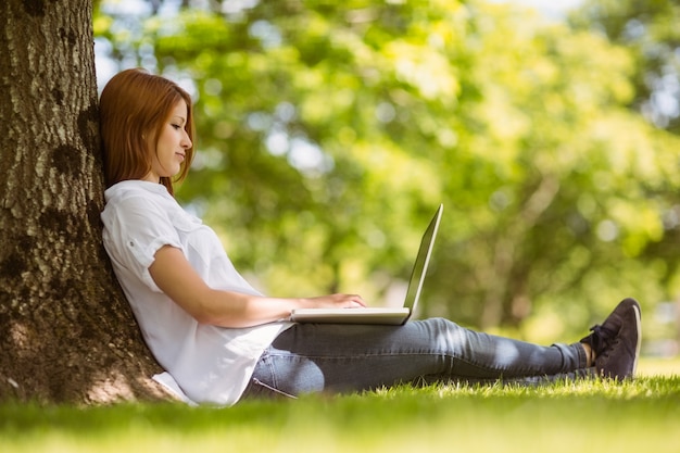 Pretty redhead sitting with her laptop