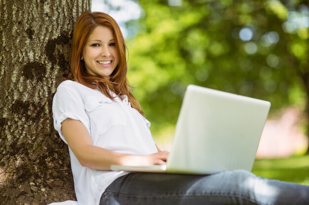 Pretty redhead sitting with her laptop