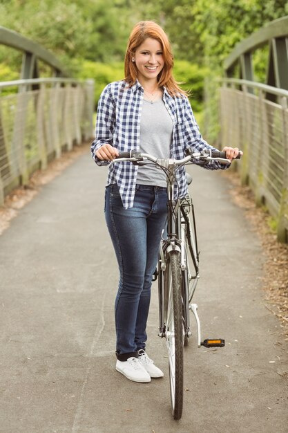 Pretty redhead with her bike smiling at camera