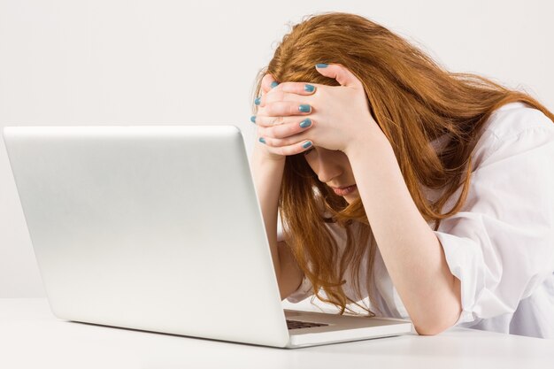 Pretty redhead working on laptop