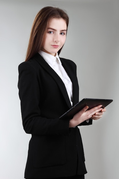 Pretty schoolgirl holding newly launched tablet pc Surfing the net