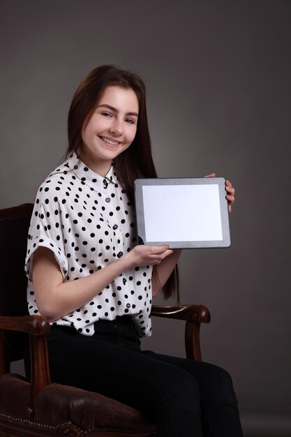 Pretty schoolgirl holding newly launched tablet pc Surfing the net