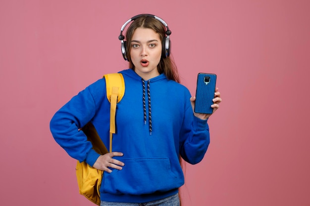 Pretty schoolgirl standing with open mouth looking at camera