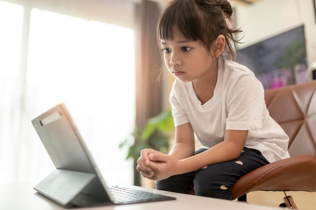 Bella studentessa che studia i compiti durante la sua lezione online a casa distanza sociale durante la quarantena autoisolamento concetto di educazione online homeschooler