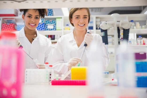 Pretty science students using pipette