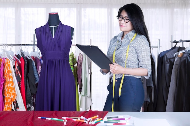 Pretty seamstress working with a clipboard