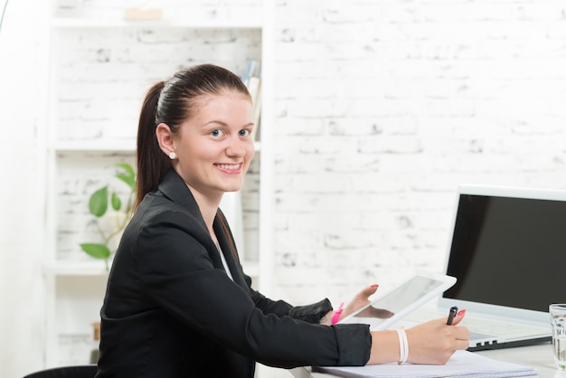 A pretty secretary looking at a digital tablet