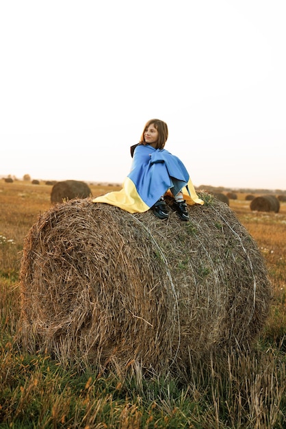 Довольно стройная девушка с желто-голубым флагом украины в полевом образе жизни любит украину